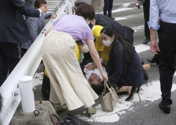 Former Japanese prime minister Shinzo Abe lies on the ground after apparent shooting in Nara, western Japan, on July 8, 2022. (Kyodo via Reuters)