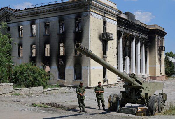 Service members of pro-Russian troops stand next to a howitzer during an exhibition of Ukrainian army hardware and weapons left in the city after its withdrawal during the Ukraine-Russia conflict, in Lysychansk, Luhansk Region, Ukraine, on July 8, 2022. (Alexander Ermochenko/Reuters)
