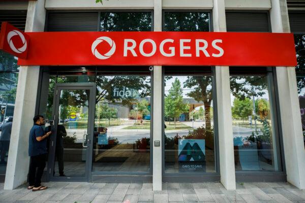 A man stands outside a locked Rogers wireless store in Toronto amid a countrywide outage of the telecommunication company's services, on July 8, 2022. (The Canadian Press/Cole Burston)