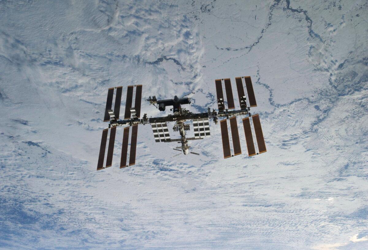 Backdropped against clouds over Earth, the International Space Station is seen from Space Shuttle Discovery as the two orbital spacecraft accomplish their relative separation on March 7, 2011. (NASA via AP)