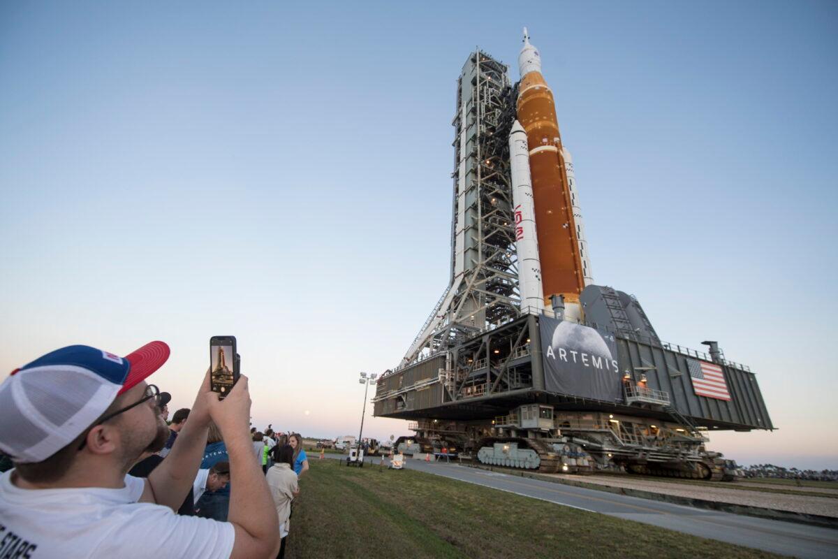 Invited guests and NASA employees take photos of a NASA rocket carrying the Orion spacecraft at the Kennedy Space Center near Cape Canaveral, Fla., on March 17, 2022. (Aubrey Gemignani/NASA via AP)