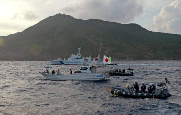 Japanese Coast Guard vessel and boats (rear and right) sail alongside a Japanese activists’ fishing boat (center) near the disputed Senkaku Islands,  in the East China Sea, on Aug. 18, 2013. (Emily Wang/AP Photo)