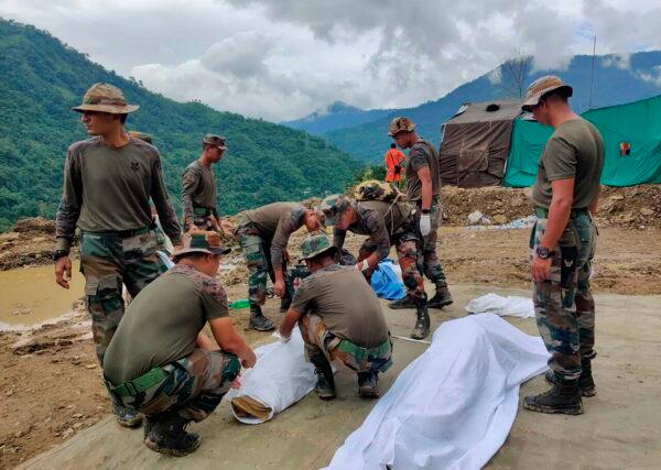 Soldiers wrap bodies of victims of a mudslide in Noney, northeastern Manipur state, India, on July 1, 2022. (Agui Kamei/AP Photo)