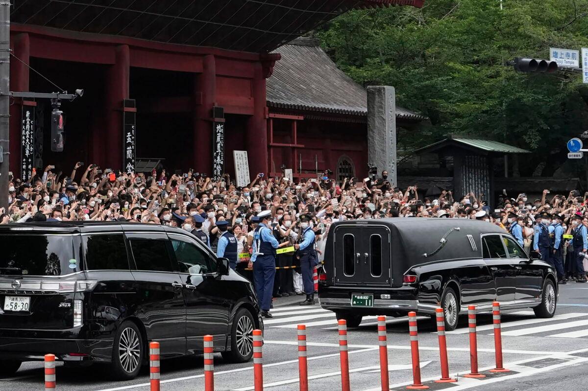 The vehicle (R) carrying the body of former Japanese Prime Minister Shinzo Abe leaves Zojoji temple after his funeral in Tokyo on July 12, 2022. (Hiro Komae/AP Photo)