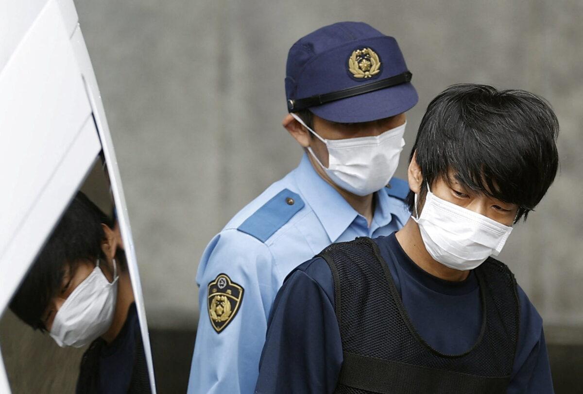 Tetsuya Yamagami, suspected of killing former Japanese Prime Minister Shinzo Abe, is escorted by a police officer as he is taken to prosecutors, at Nara-nishi police station in Nara, western Japan, on July 10, 2022. (Kyodo via Reuters)