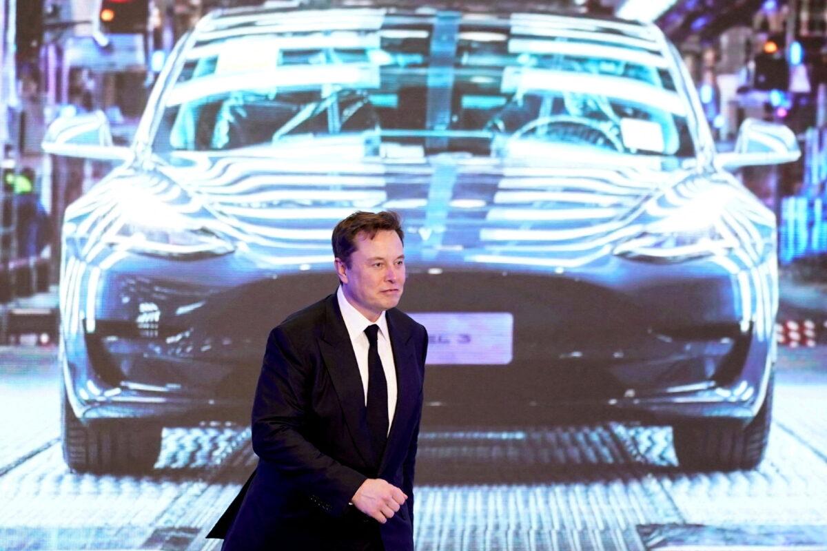 Tesla Inc. CEO Elon Musk walks next to a screen showing an image of Tesla Model 3 car during an opening ceremony for Tesla China-made Model Y program in Shanghai on Jan. 7, 2020. (Aly Song/Reuters)