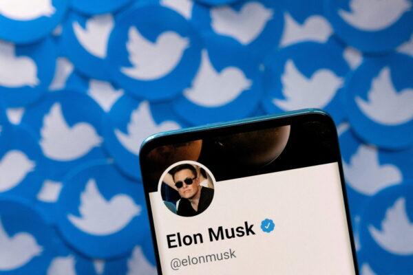 A smartphone with Elon Musk's Twitter profile is placed on printed Twitter logos in this picture illustration taken on April 28, 2022. (Dado Ruvic/Reuters)