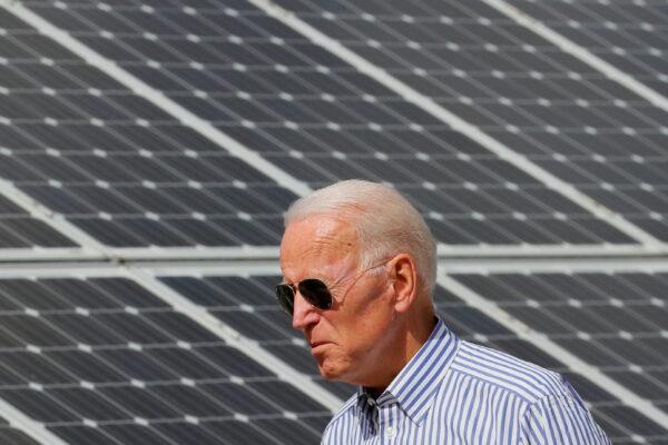 Joe Biden walks past solar panels while touring the Plymouth Area Renewable Energy Initiative in Plymouth, New Hampshire, on June 4, 2019. (Brian Snyder/Reuters)
