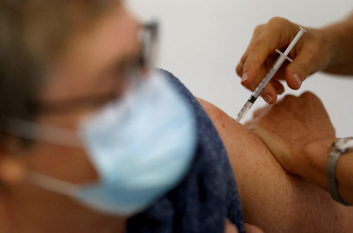 A medical worker administers a dose of the "Cominarty" Pfizer-BioNTech COVID-19 vaccine to a patient at a vaccination center in Ancenis-Saint-Gereon, France, on Nov. 17, 2021. (Stephane Mahe/File Photo/File Photo/Reuters)