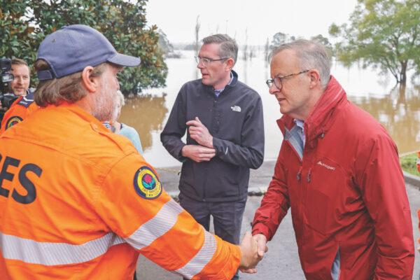 Australian Prime Minister Anthony Albanese (R) shakes hands with State Emergency Service workers on a tour of flood-affected areas with New South Wales Premier Dominic Perrottet in the suburb of Richmond in Sydney, Australia, on July 6, 2022. (Jenny Evans/Getty Images)