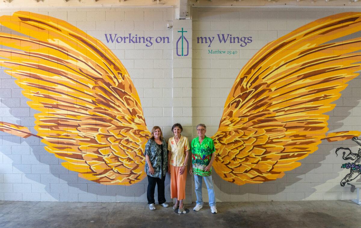 (L to R) Ellen Roy, Jean Stein, and Alan Smith stand in the warehouse of the Catholic Charities of Orange County in Santa Ana, Calif., on July 7, 2022. (John Fredricks/The Epoch Times)