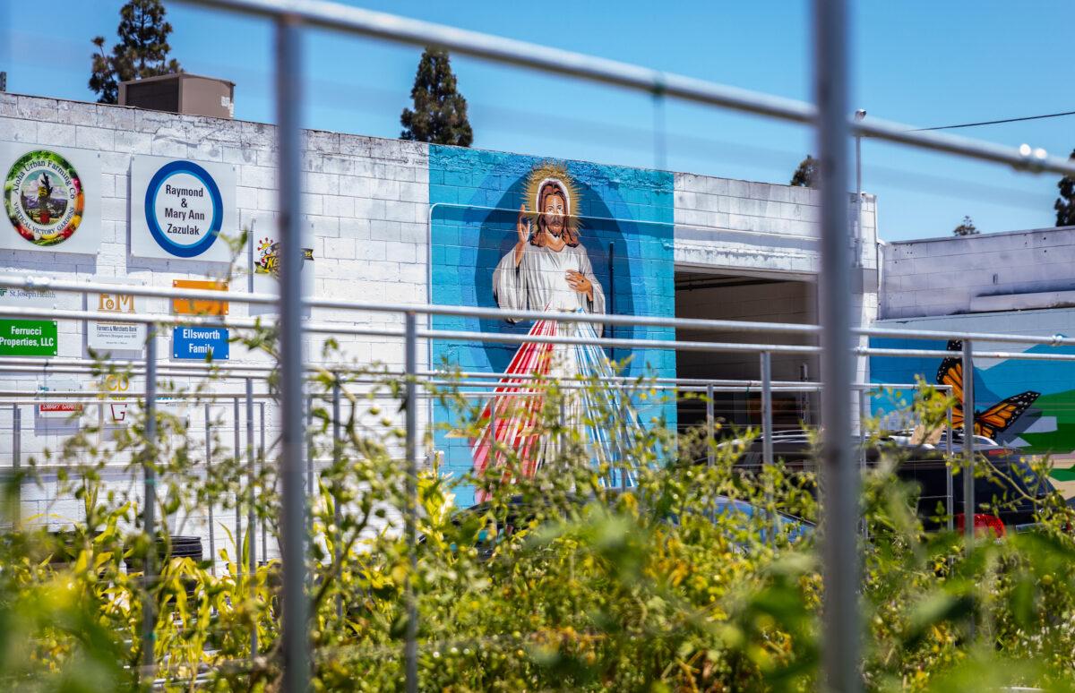 A mural of Jesus Christ sits on the outer wall of the Garden of Hope, located behind the Catholic Charities of Orange County in Santa Ana, Calif., on July 7, 2022. (John Fredricks/The Epoch Times)