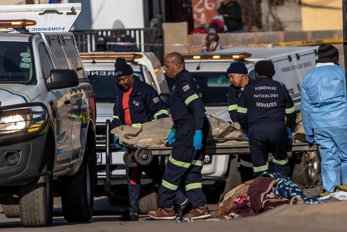 A body is removed from the scene of an overnight bar shooting in Soweto, South Africa, on July 10, 2022. (Shiraaz Mohamed/AP Photo)