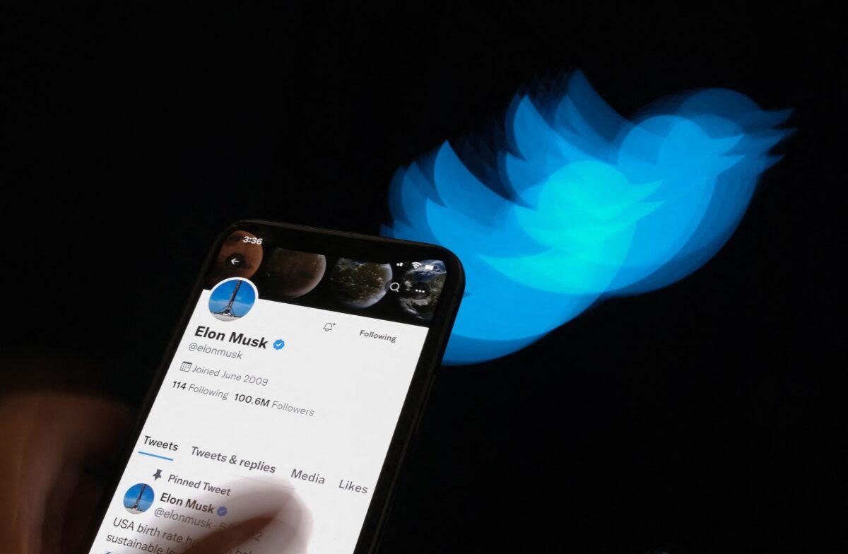 Elon Musk's Twitter page displayed on the screen of a smartphone with Twitter logo in the background in Los Angeles on July 8, 2022. (Chris Delmas/AFP via Getty Images)