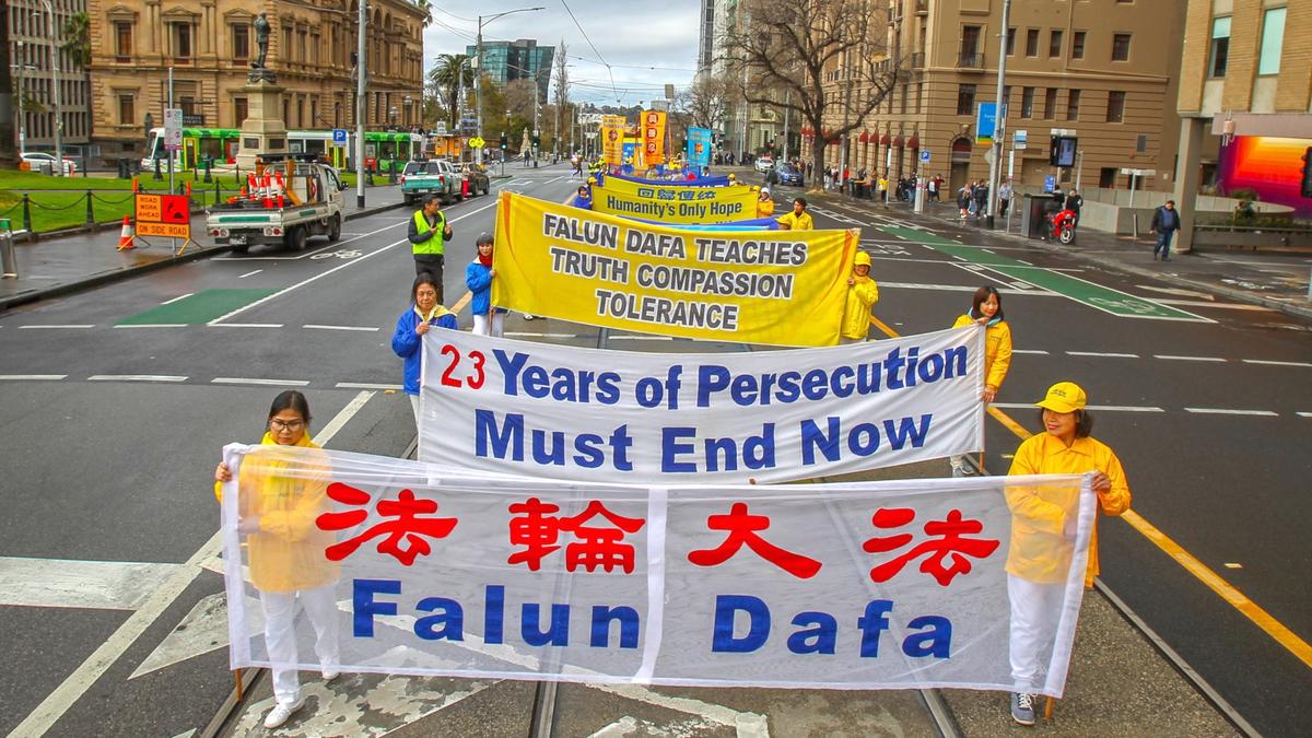 Falun Gong practitioners holding banners as they walk along Spring St., Melbourne, Australia, during a commemoration event on July 9, 2022. (Chen Ming/Epoch Times)