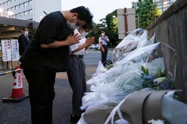 Mourners offer flowers for former Japanese Prime Minister Shinzo, at the entrance of the Liberal Democratic Party (LDP) headquarters building in Tokyo, Japan, on July 10, 2022. (Toru Hana/Pool via AP)