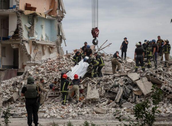 Rescuers extract a body from a residential building damaged by a Russian military strike in the town of Chasiv Yar, in Donetsk region, Ukraine, on July 10, 2022. (Gleb Garanich/Reuters)