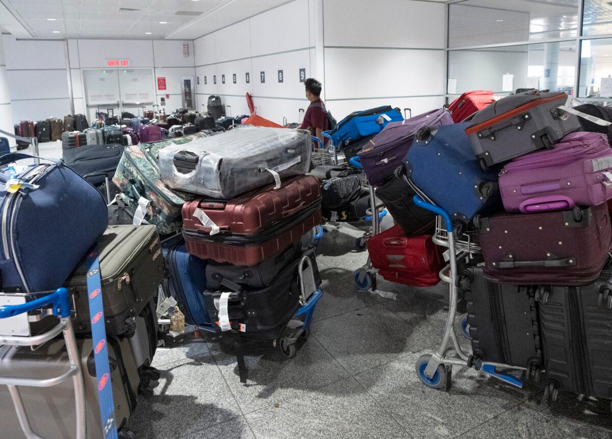 A passenger looks for his luggage among a pile of unclaimed baggage at Pierre Elliott Trudeau airport in Montreal on June 29, 2022. (Ryan Remiorz/The Canadian Press)