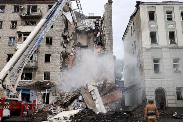 Firefighters remove debris after a military strike hit a building in Kharkiv, Ukraine, on July 11, 2022. (Nacho Doce/Reuters)