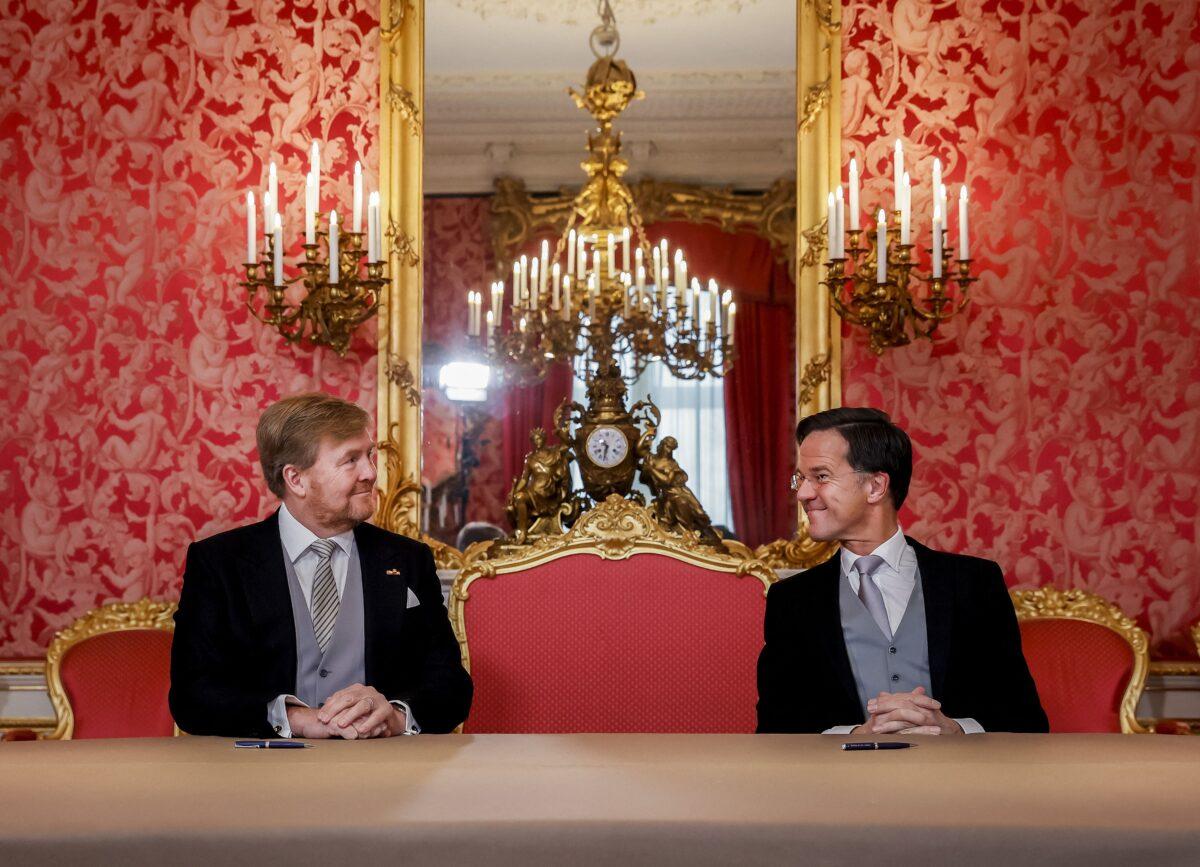King Willem-Alexander (L) and Prime Minister Mark Rutte of the Netherlands sign the Royal Decrees as part of the inauguration of the new prime minister's cabinet at Noordeinde Palace in The Hague on Jan. 10, 2022. (Sem Vander Wal/AFP via Getty Images)