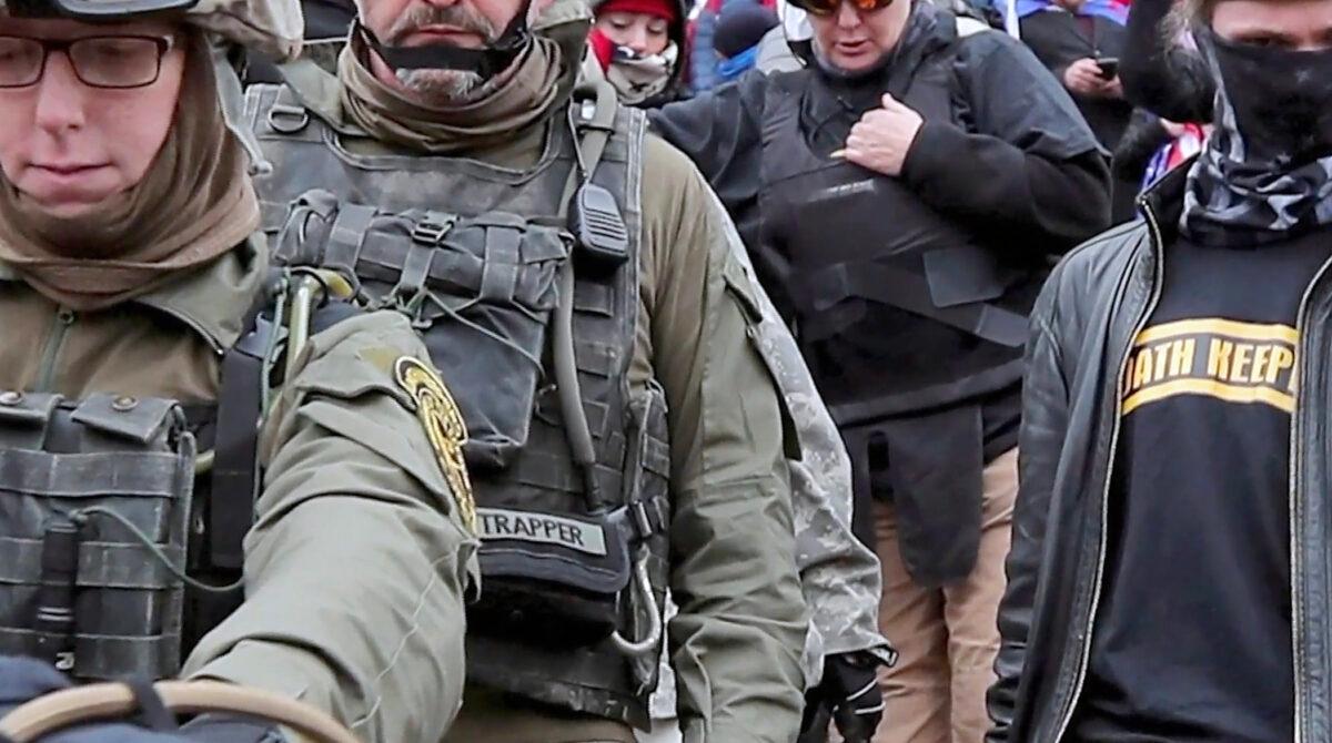 Oath Keepers defendant Jessica Watkins (front left) moves down the steps of the U.S. Capitol on Jan. 6, 2021. Prosecutors allege Watkins used a phone app called Zello to discuss her plans to go into the Capitol. (The Real Story of Jan. 6/Epoch TV)
