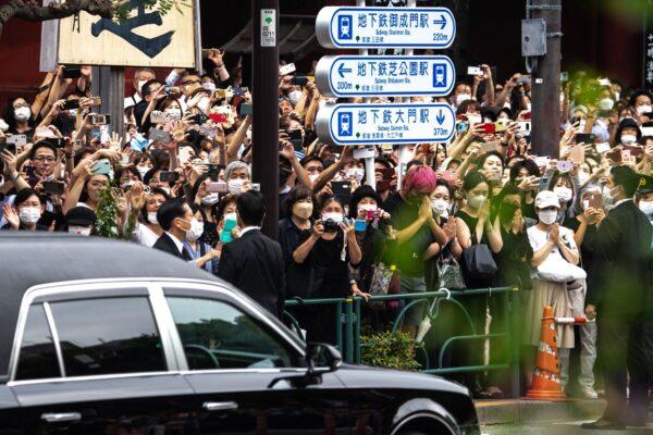 People watch the hearse transporting the body of late former Japanese prime minister Shinzo Abe as it leaves Zojoji Temple in Tokyo, Japan, on July 12, 2022. (Philip Fong/AFP via Getty Images)
