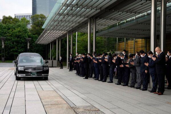 A hearse transporting the body of Japan's former prime minister Shinzo Abe makes a brief visit to the Prime Minister's Office after his funeral ceremony, as Japan's Prime Minister Fumio Kishida, officials and employees offer prayers in Tokyo, Japan, on July 12, 2022. (Eugene Hoshiko/Pool/AFP via Getty Images)