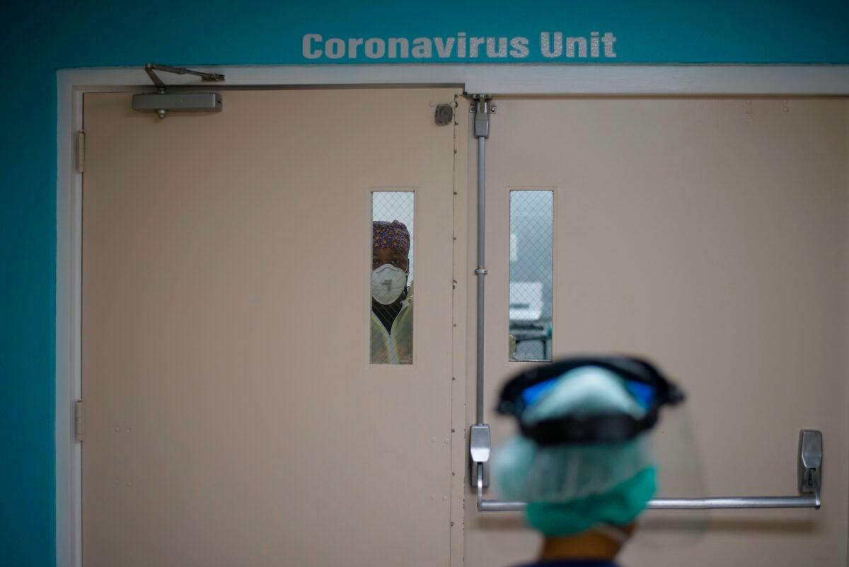 A healthcare worker looks out from a window in the door to the COVID-19 Unit at United Memorial Medical Center in Houston, Texas, on July 2, 2020. (Mark Felix/AFP via Getty Images)