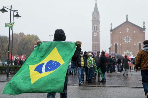 A supporter holds the Brazilian flag prior to the expected arrival of Brazilian President Jair Bolsonaro in Anguillara Veneta, Italy, on Nov. 1, 2021. (Piero Cruciatti/AFP via Getty Images)