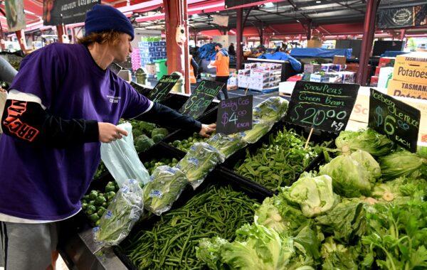 A shopper places produce in a bag at Victoria Market in Melbourne, Australia, on July 5, 2022. (William West/AFP via Getty Images)