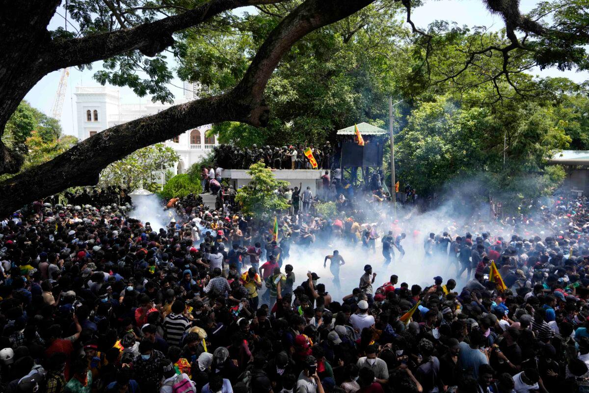 Police use tear gas as protesters storm the compound of Prime Minister Ranil Wickremesinghe 's office, demanding he resign after President Gotabaya Rajapaksa fled the country amid an economic crisis in Colombo, Sri Lanka, on July 13, 2022. (Eranga Jayawardena/AP Photo)