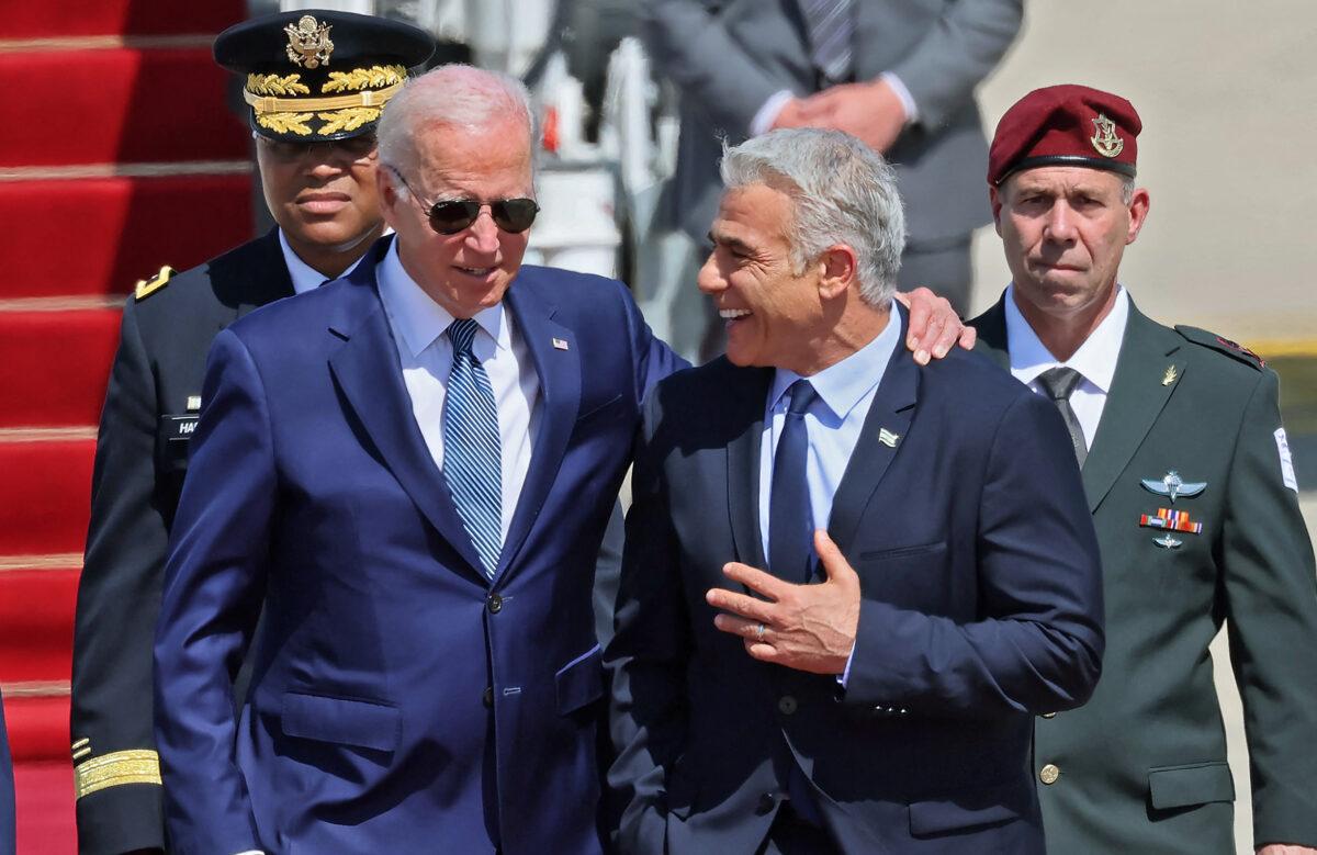  US President Joe Biden (L) is welcomed by Israeli caretaker Prime Minister Yair Lapid after arriving at Israel's Ben Gurion Airport in Lod near Tel Aviv, on July 13, 2022. (Jack Guez/AFP via Getty Images)