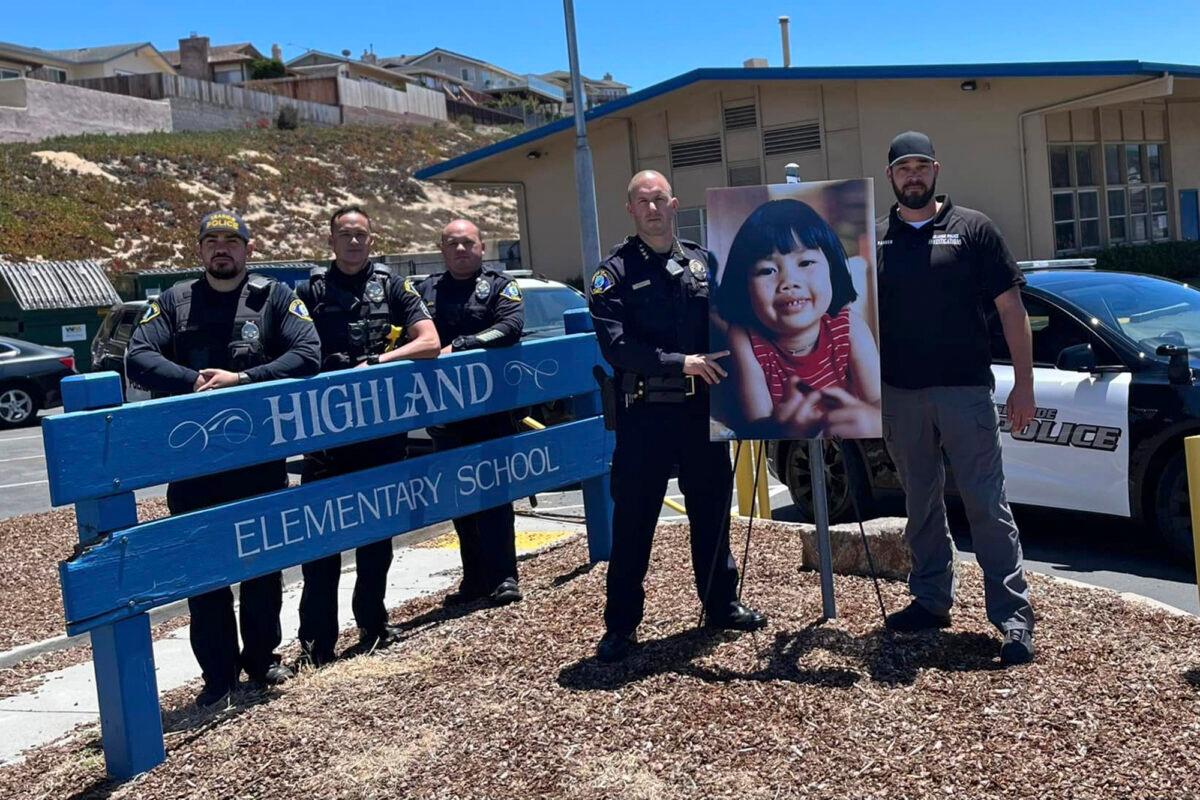 Interim Police Chief Nick Borges (2nd R) and Detective Joshua Parker (R) stand next to a photo of Anne Pham outside Highland Elementary School in Seaside, Calif., on July 7, 2022. (Seaside Police Department via AP)