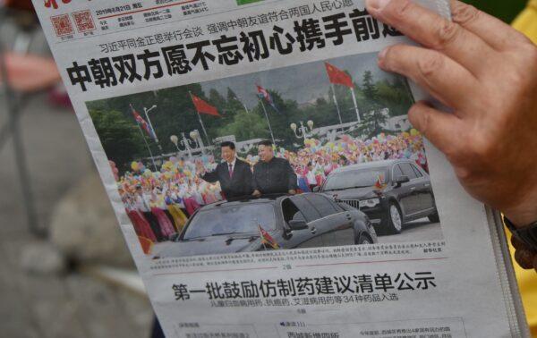 A Beijing newspaper featuring a front-page photo of Chinese leader Xi Jinping (L) riding in a limousine with North Korean leader Kim Jong Un (R) during Xi's visit to North Korea in Pyongyang, on June 21, 2019. (Greg Baker/AFP via Getty Images)