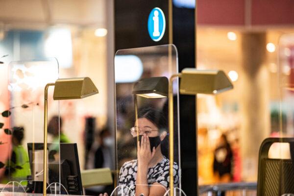 An employee adjusts her face mask as she stands at an information desk at Chadstone The Fashion Capital in Melbourne, Australia, on Dec. 26, 2021. (Diego Fedele/Getty Images)