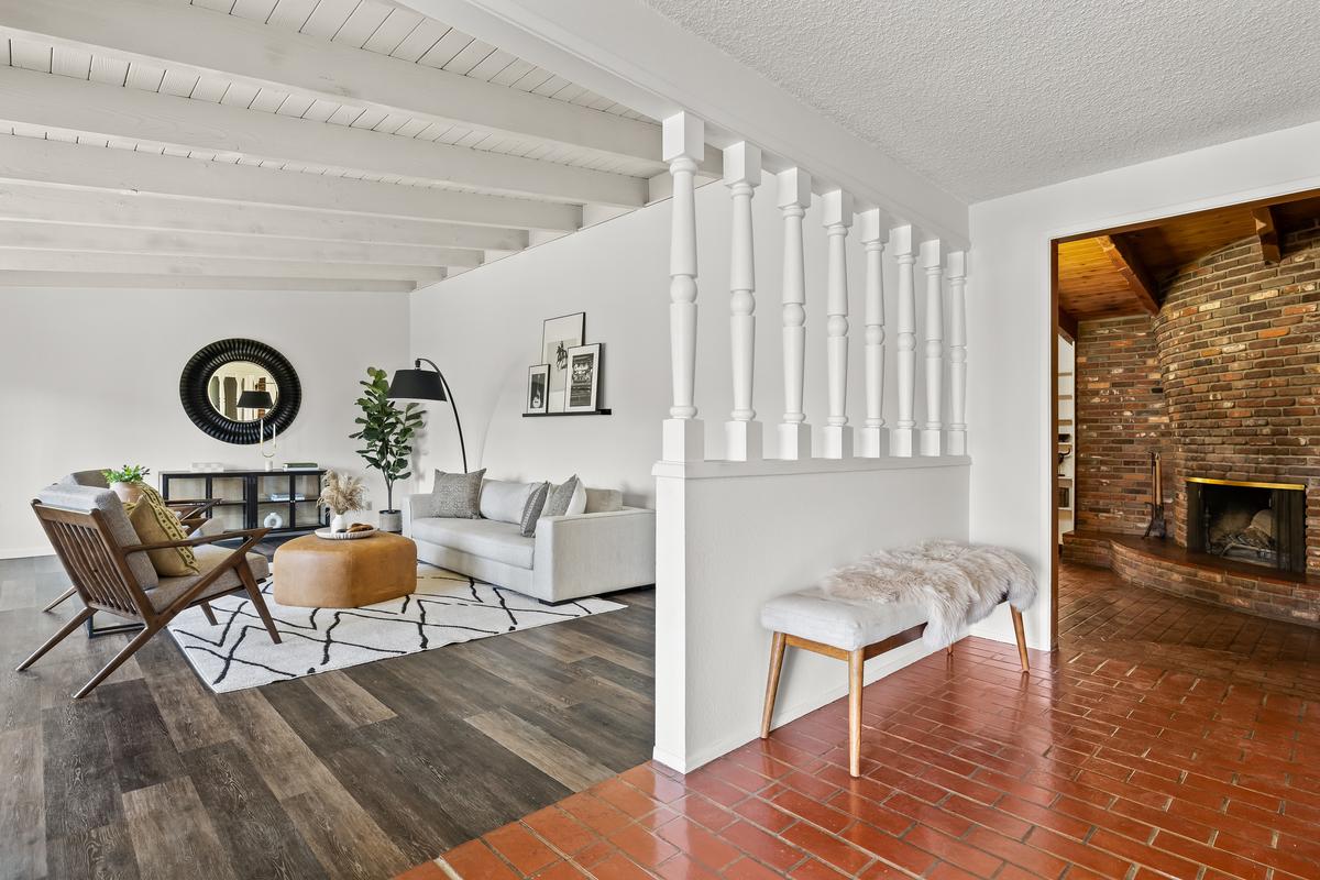 Inside, an ever present 60s-modern vibe has been retained. The entrance foyer connects with a casual living room and the stunning family room with a circular brick fireplace. (Courtesy of Mark Corcoran for Douglas Elliman Realty)