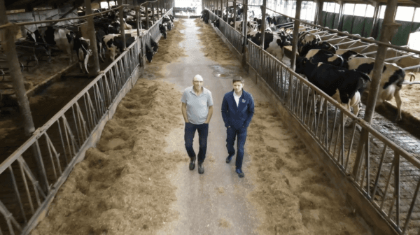 Dutch dairy farmer Martin Neppelenbroek and EpochTV host Roman Balmakov at Neppelenbroek's farm in Lemelerveld, Netherlands, on July 7, 2022. (The Epoch Times)