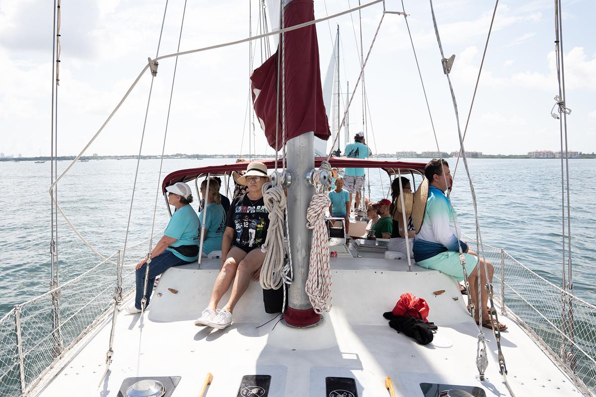People onboard the Magic, the largest sailboat in the Soothe Our Souls fleet, do yoga on Sunday, July 3, 2022. (Angelica Edwards/Tampa Bay Times/TNS)