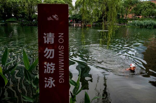 A man swims in the Liangma River on a hot summer day in Beijing, China on July 12, 2022. Parts of China are enduring some of the worst heat waves in years with temperatures reaching 40 degrees Celsius (104 degrees Fahrenheit) in some areas. (Kevin Frayer/Getty Images)
