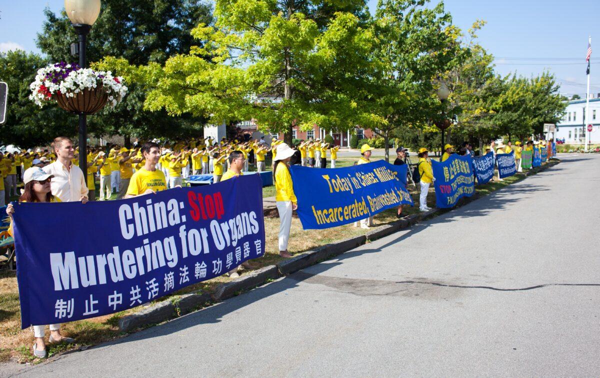 Falun Gong adherents hold banners along a road in Goshen., N.Y., on July 17, 2022. A few hundred adherents of the spiritual practice gathered in the town to commemorate 23 years since the Chinese Communist Party launched a persecution of their fellows in faith in China. (Petr Svab/The Epoch Times)