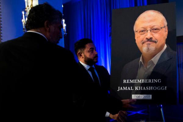"Justice for Jamal" campaign leader Ahmed Bedier (center) adjusts a portrait of late Washington Post journalist Jamal Khashoggi during a remembrance ceremony for him in Washington on Nov. 2, 2018. (Jim Watson/AFP via Getty Images)