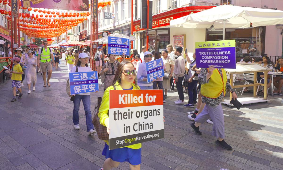 Falun Gong practitioners marching to highlight the 23rd year of persecution in China against the spiritual discipline, in London on July 16, 2022. (Yanning Qi/The Epoch Times)