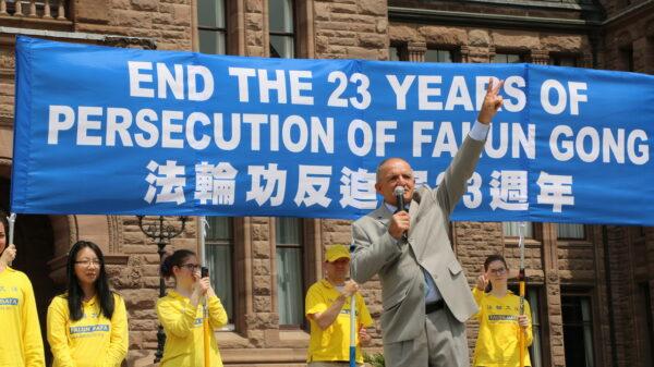  Former Conservative MP Wladyslaw Lizon gives the victory sign as he speaks during a rally held by Falun Gong practitioners in downtown Toronto on July 17, 2022. (Andrew Chen/The Epoch Times)