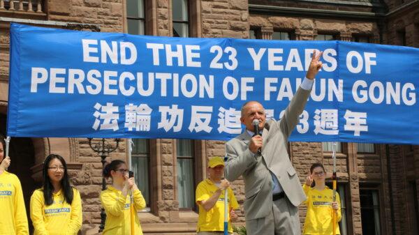 Former Conservative MP Wladyslaw Lizon gives the victory sign as he speaks during a rally held by Falun Gong practitioners in downtown Toronto on July 17, 2022. (Andrew Chen/The Epoch Times)