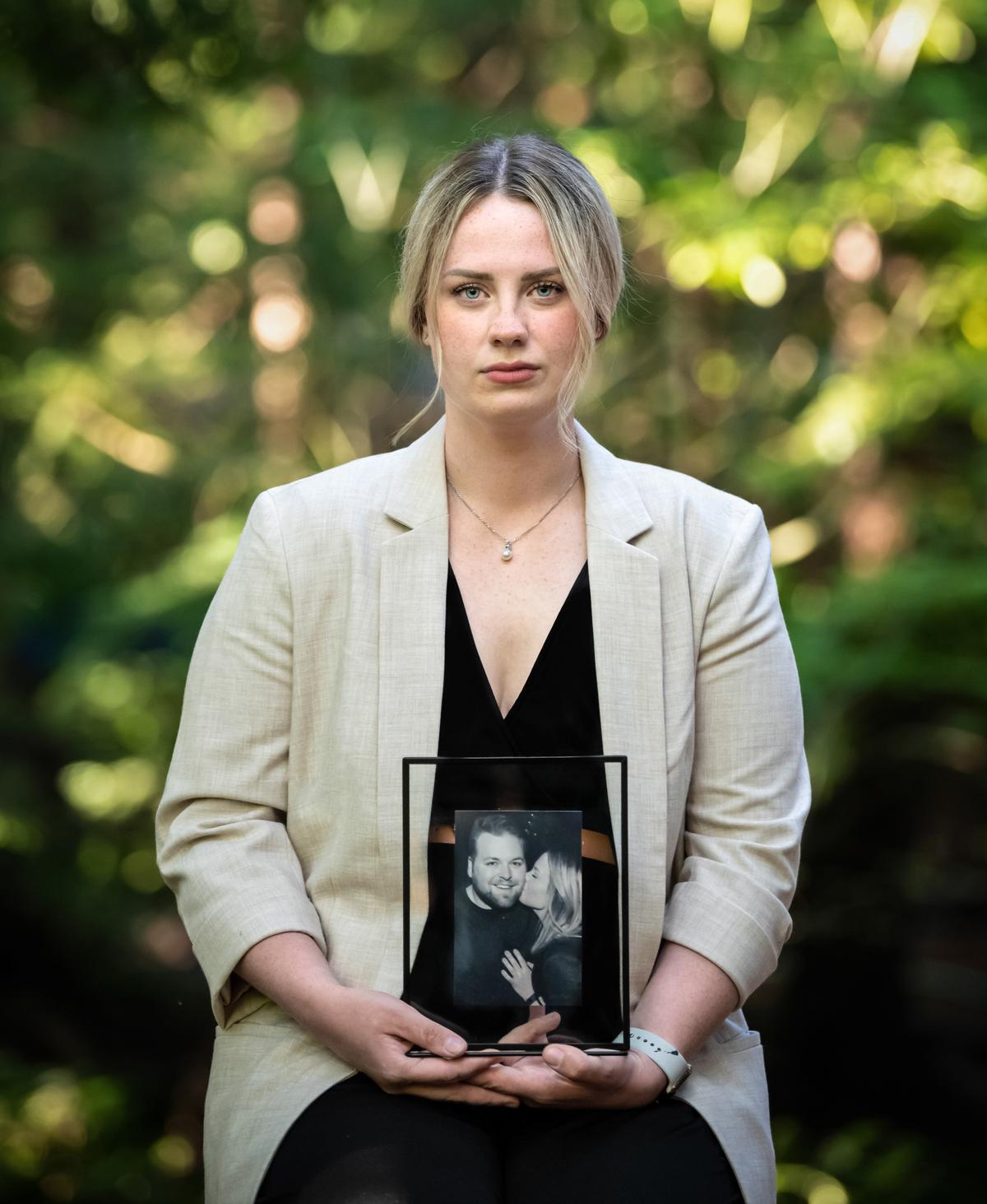 Ashley Wines, a nursing student, holds a photo of her late 32-year-old fiancé Phillip Carron on July 12, 2022. (Morgan Henry Photography for The Epoch Times)