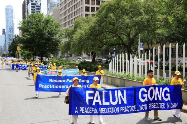  Falun Gong adherents participate in a parade in downtown Toronto on July 17, 2022, calling for an end to the persecution of their fellow adherents in China. (Evan Ning/The Epoch Times)