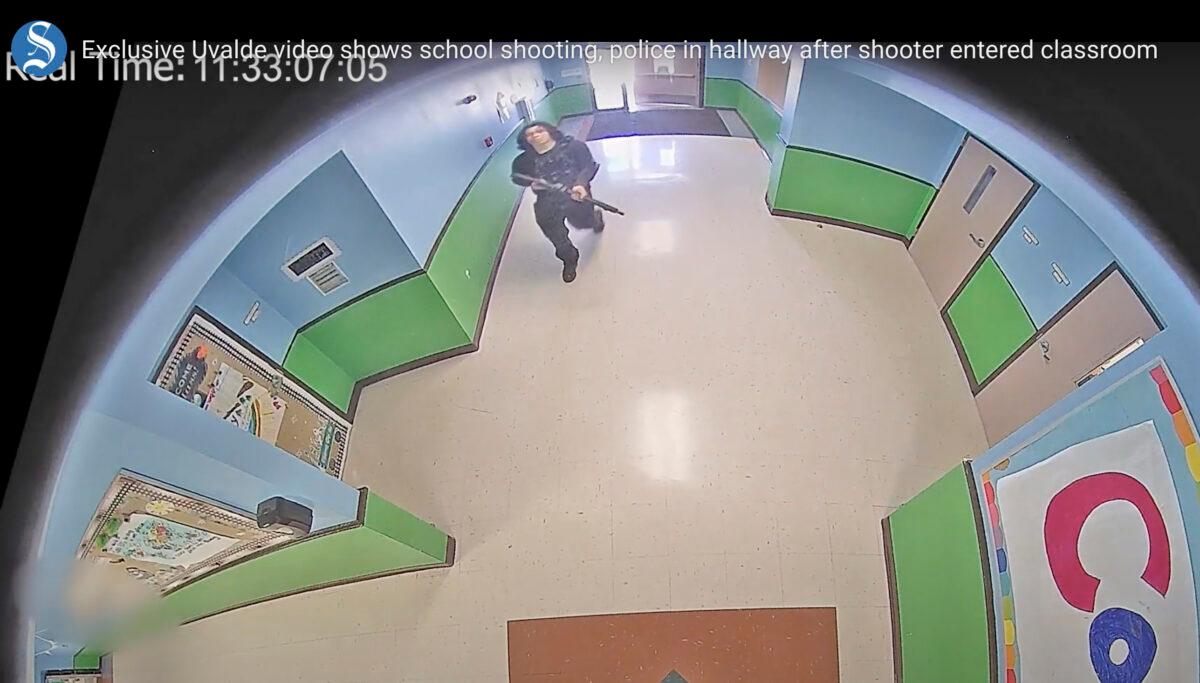 In this image from surveillance video, a gunman carrying a rifle enters and walks down a hallway at Robb Elementary School in Uvalde, Texas, on May 24, 2022. (Uvalde Consolidated Independent School District/Austin American-Statesman via AP)