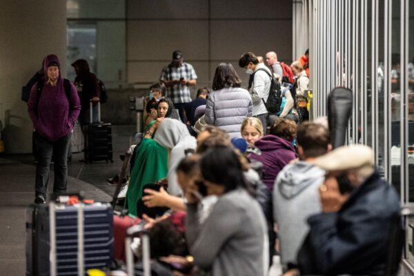 People wait outside the International Arrival terminal at San Francisco International Airport after a reported bomb threat forced an evacuation in San Francisco, Calif., on July 15, 2022. (Stephen Lam/San Francisco Chronicle via AP)