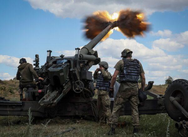 Ukrainian service members fire a shell from a towed howitzer FH-70 at a front line in Donbass Region on July 18, 2022. (Gleb Garanich/Reuters)