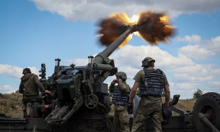 Ukrainian service members fire a shell from a towed howitzer FH-70 at a front line in the Donbass Region on July 18, 2022. (Gleb Garanich/Reuters)